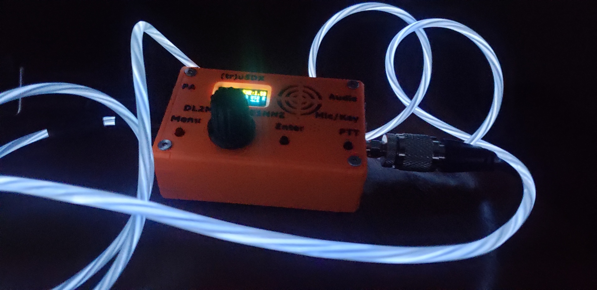 A small orange radio surrounded by glowing wires.