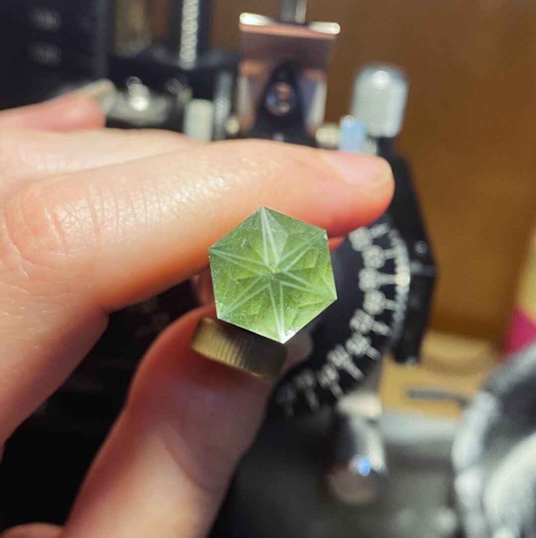 a white six pointed star on the bottom of a gemstone
